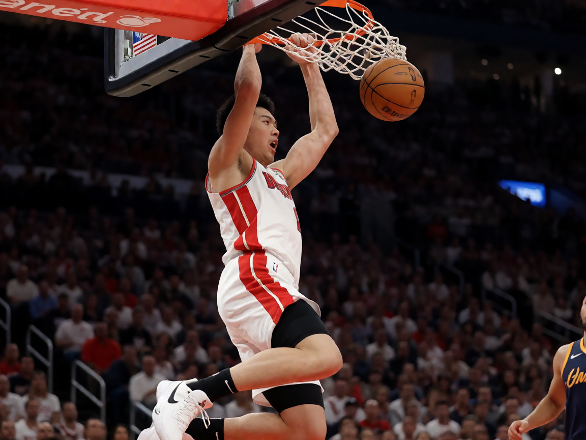 NBA篮球比赛现场，球员在球场上进行精彩扣篮